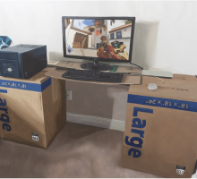 Realist oilpainting of a desk made out of two cardboard boxes with a computer screen in the center