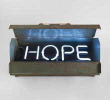 A toolbox with neon letters inside that read 